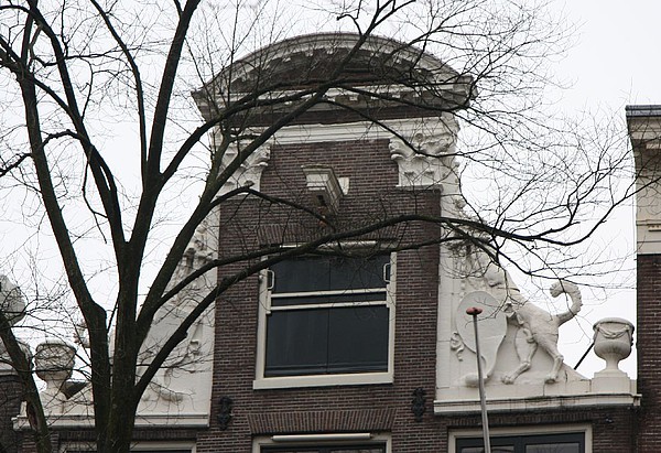 Herengracht 504 Halsgevel met klimmende honden, een doodsbeen en een wapenschild